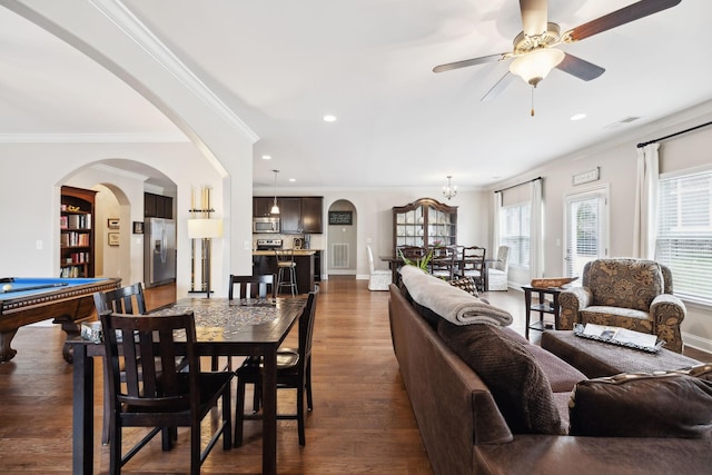 dining area featuring arched walkways, dark wood-type flooring, visible vents, and crown molding