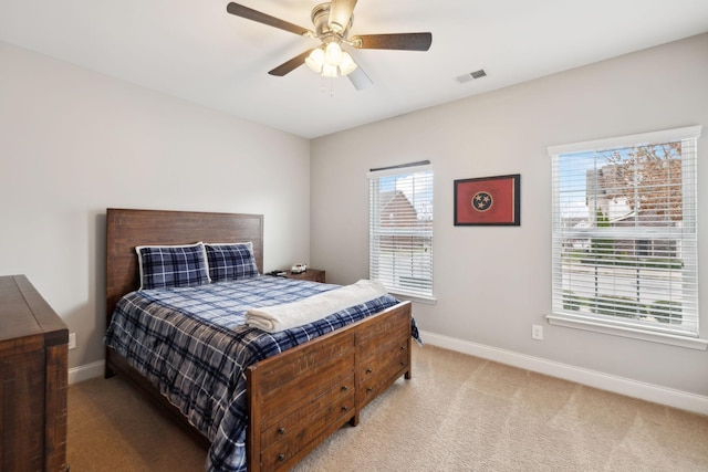 bedroom with baseboards, a ceiling fan, visible vents, and light colored carpet