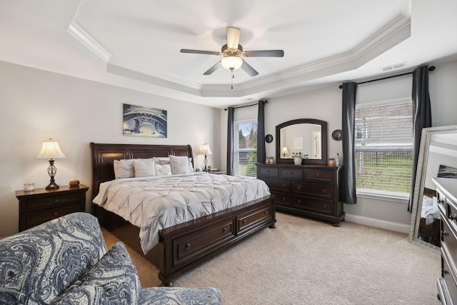 bedroom with light colored carpet, a tray ceiling, visible vents, and baseboards