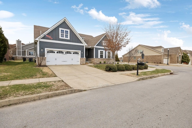 craftsman house with board and batten siding, concrete driveway, a front lawn, and a garage