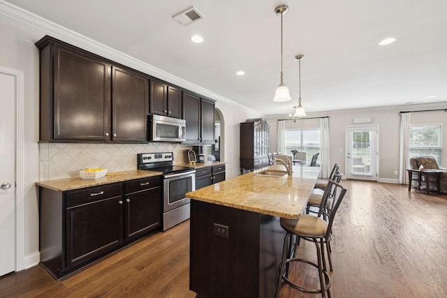 kitchen with a breakfast bar, crown molding, tasteful backsplash, appliances with stainless steel finishes, and a sink