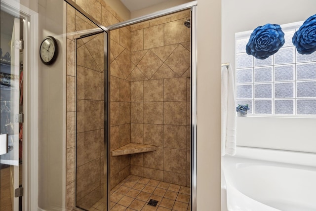 full bathroom featuring a wealth of natural light, a stall shower, and a bath