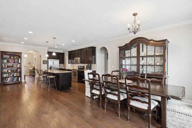 dining room featuring arched walkways, dark wood finished floors, and an inviting chandelier