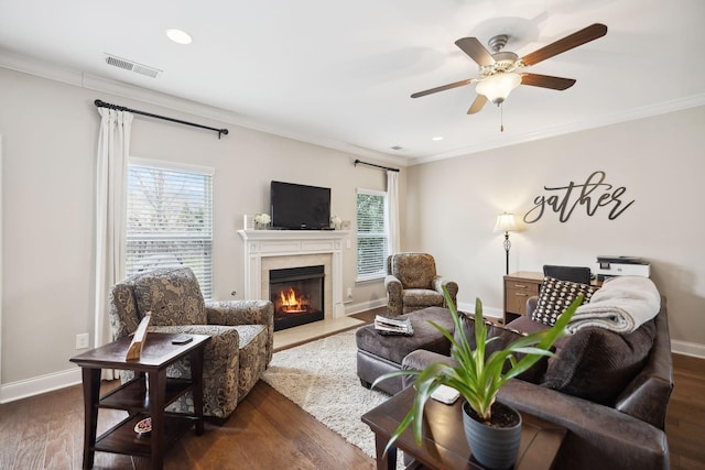 living room featuring a wealth of natural light, ornamental molding, and visible vents