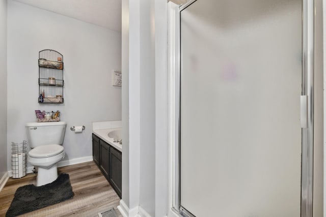 bathroom featuring a stall shower, visible vents, toilet, and wood finished floors