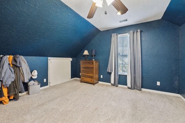 additional living space featuring carpet, lofted ceiling, visible vents, a ceiling fan, and a textured ceiling