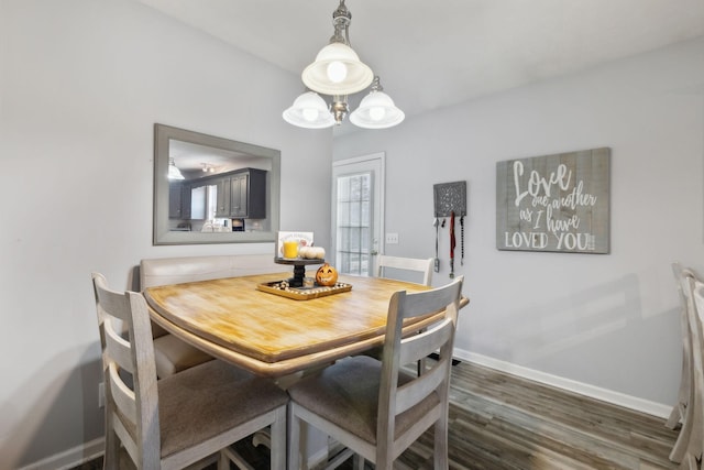 dining area with dark wood-style flooring and baseboards