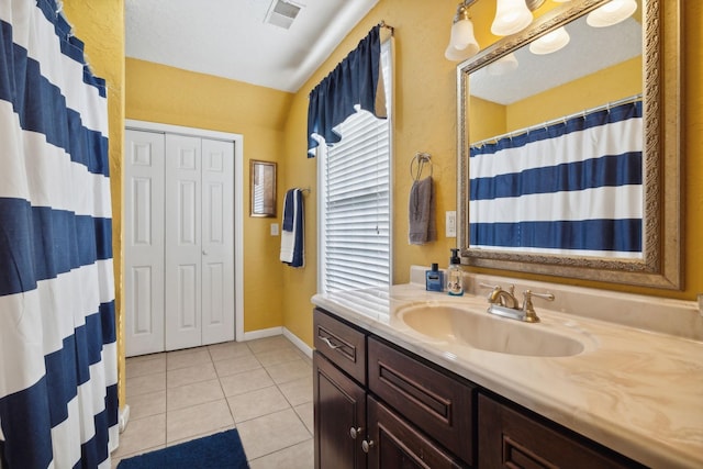 bathroom with curtained shower, visible vents, vanity, tile patterned flooring, and baseboards