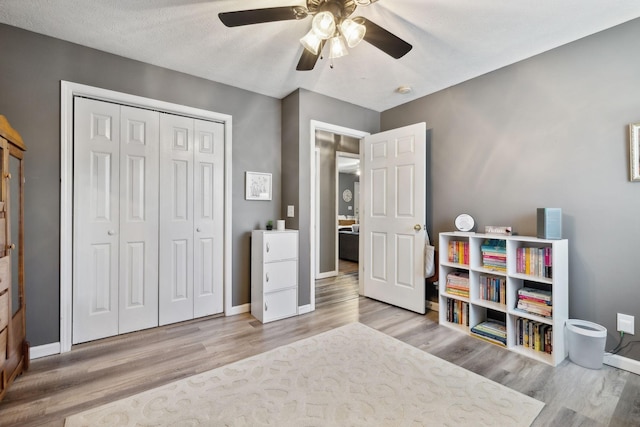 playroom with ceiling fan, wood finished floors, and baseboards