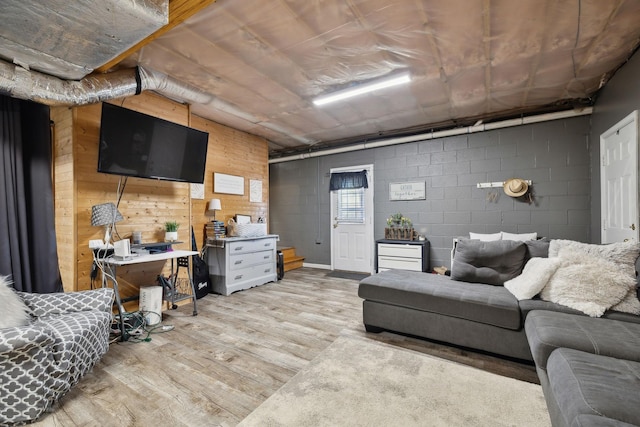 living room featuring concrete block wall and wood finished floors