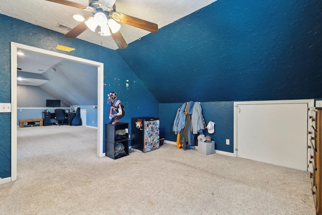 additional living space featuring carpet, visible vents, vaulted ceiling, and a textured ceiling