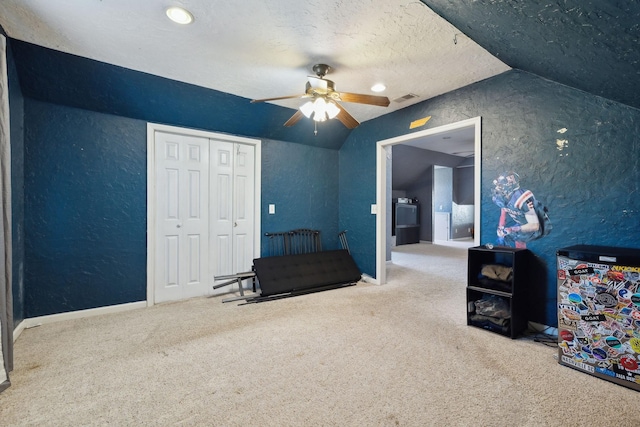 interior space featuring lofted ceiling, a closet, visible vents, a textured wall, and a textured ceiling