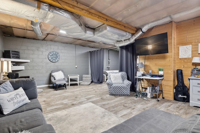 living area featuring concrete block wall and wood finished floors