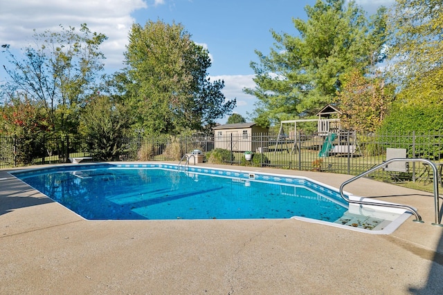 view of pool featuring a fenced in pool, a patio area, fence, and a playground