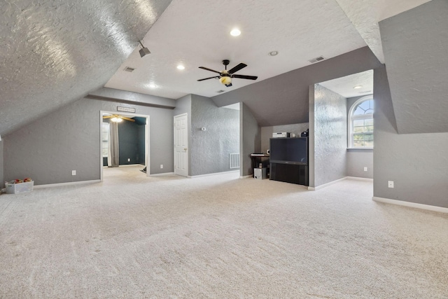 bonus room featuring a textured ceiling, carpet floors, vaulted ceiling, and visible vents