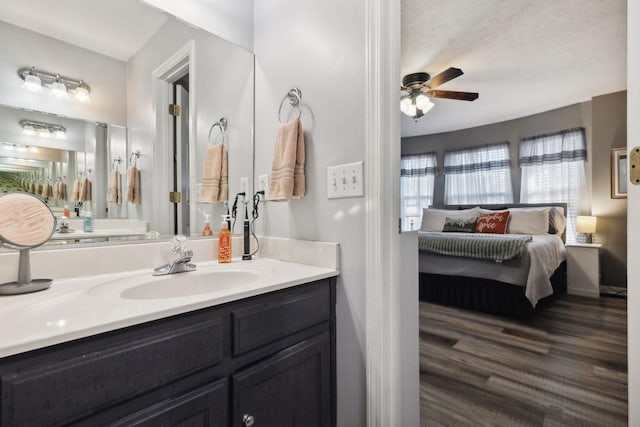 bathroom featuring ensuite bathroom, ceiling fan, wood finished floors, and vanity