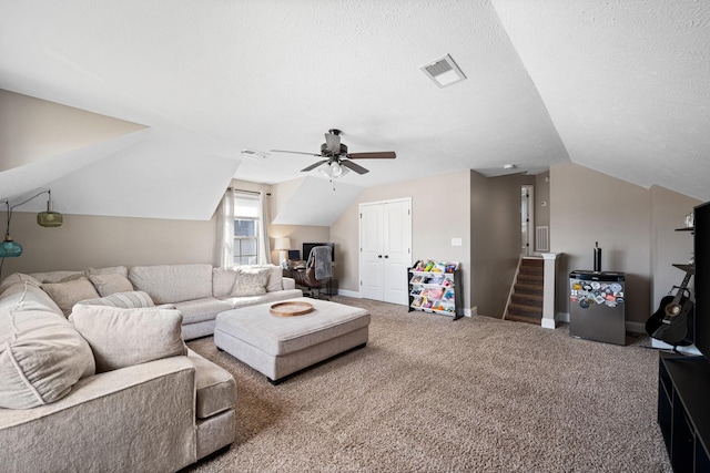 living room with a textured ceiling, vaulted ceiling, carpet flooring, and visible vents