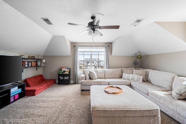 carpeted living area with lofted ceiling, a textured ceiling, and visible vents