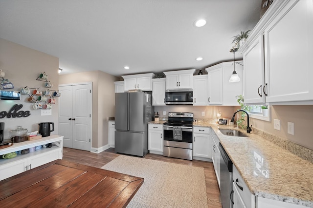 kitchen with stainless steel appliances, white cabinets, and a sink