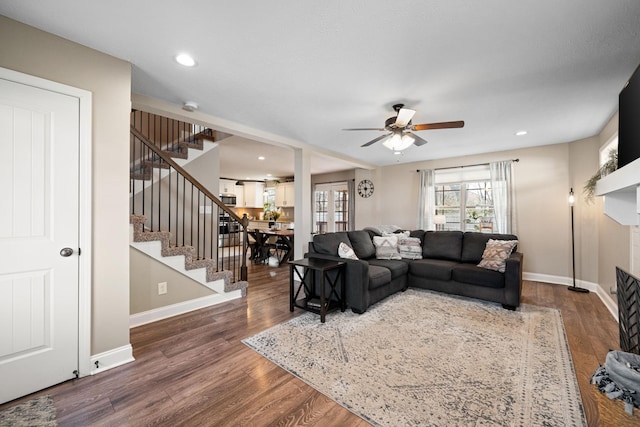 living room featuring stairs, wood finished floors, and baseboards