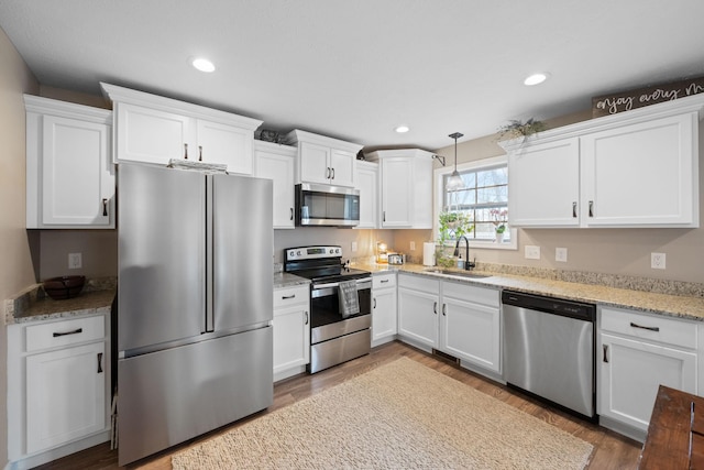 kitchen featuring appliances with stainless steel finishes, a sink, and white cabinetry