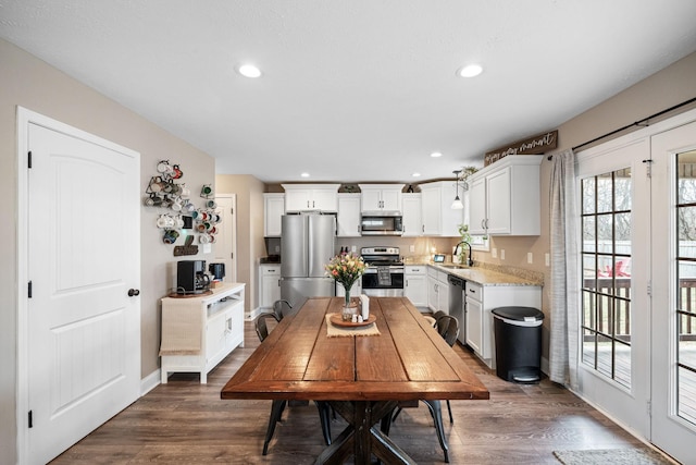 dining space with baseboards, dark wood-type flooring, and recessed lighting