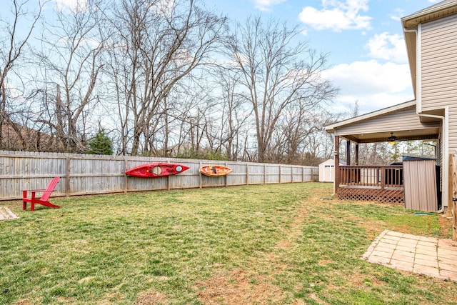 view of yard with a fenced backyard, an outdoor structure, and a storage shed