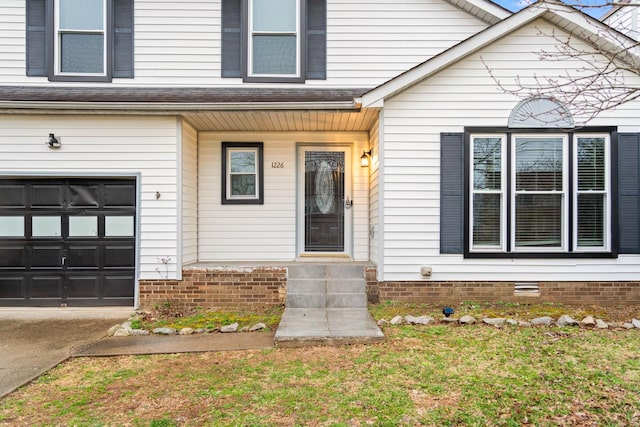 entrance to property featuring a garage and crawl space