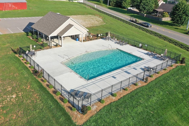 view of pool featuring fence and a lawn