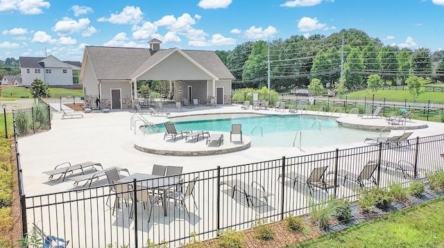 community pool with a patio and fence