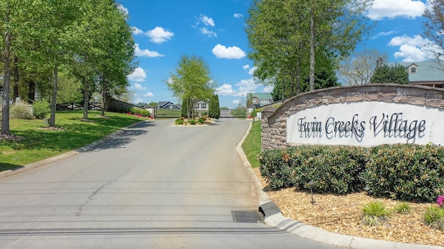 view of road featuring curbs and a gated entry