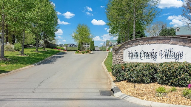 view of street with curbs and a gated entry