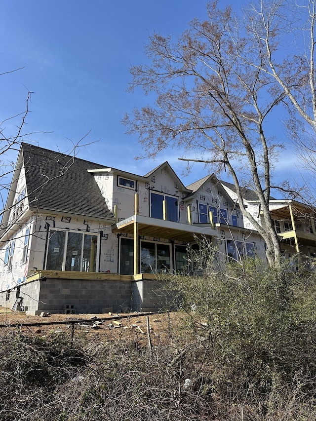 back of property featuring roof with shingles