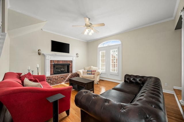 living room featuring a brick fireplace, crown molding, and wood finished floors