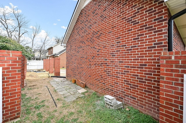 view of home's exterior featuring fence and brick siding