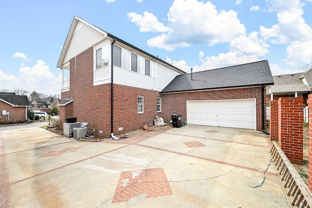 view of side of home featuring a garage, concrete driveway, and brick siding