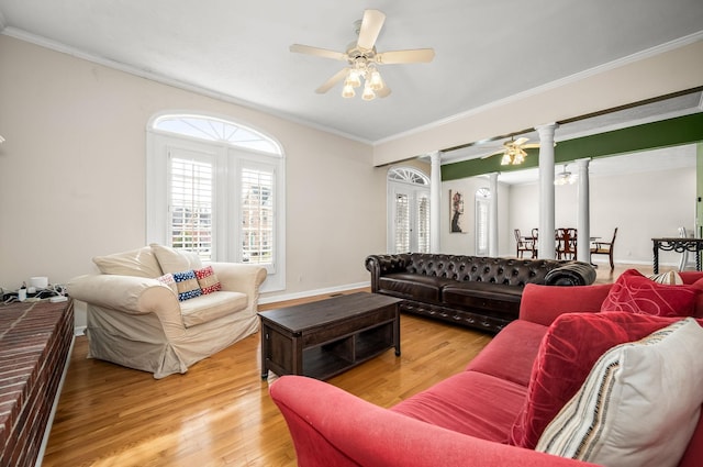 living area with ornamental molding, wood finished floors, a ceiling fan, and ornate columns