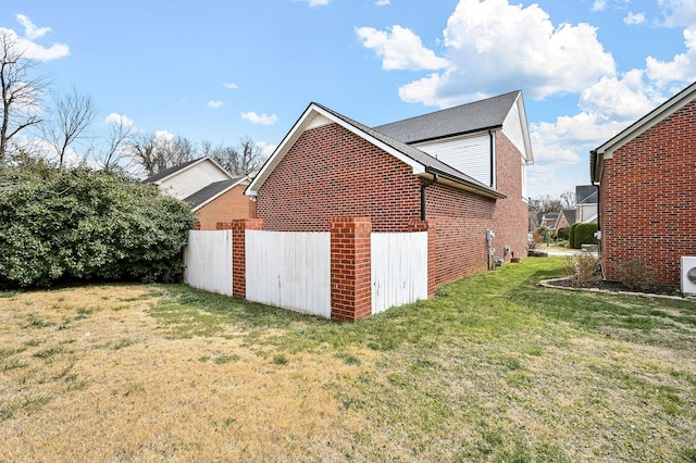 view of property exterior featuring brick siding and a yard