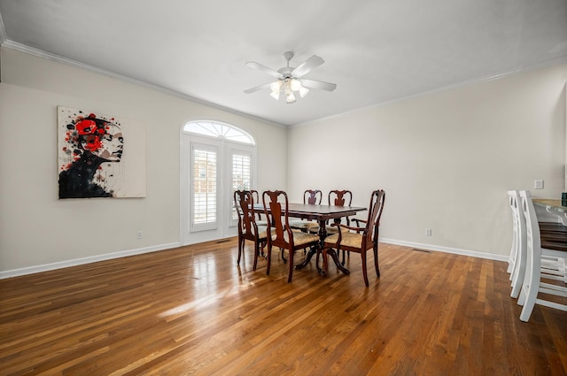 dining room with baseboards, ceiling fan, wood finished floors, and crown molding