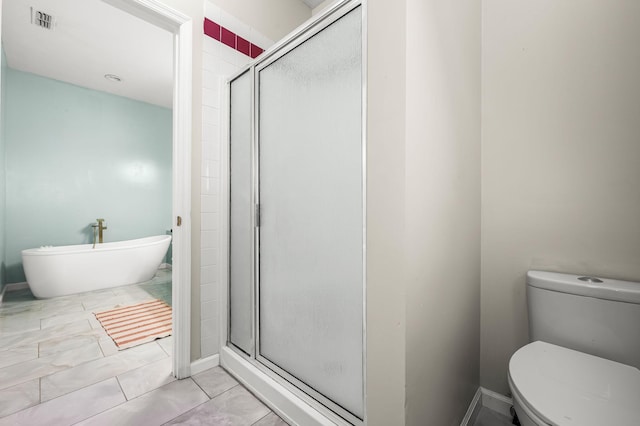 bathroom featuring visible vents, toilet, a stall shower, a freestanding tub, and tile patterned floors