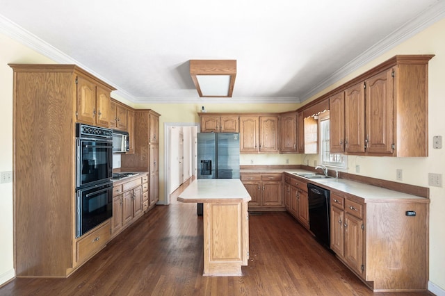 kitchen with dark wood-style floors, a center island, light countertops, ornamental molding, and black appliances