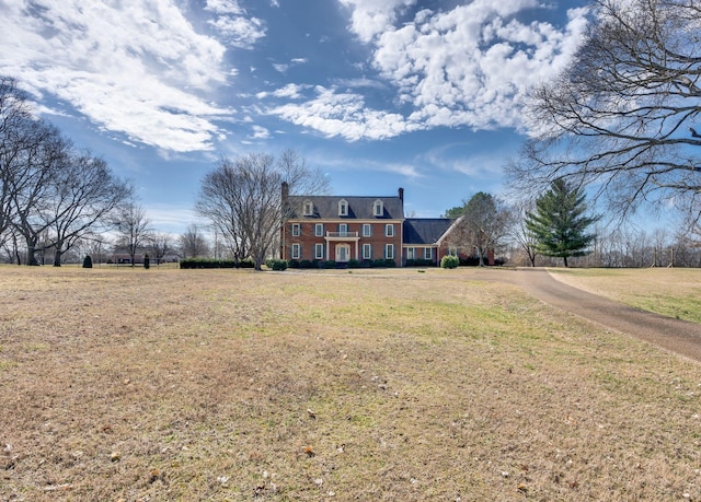 exterior space featuring a chimney and a lawn