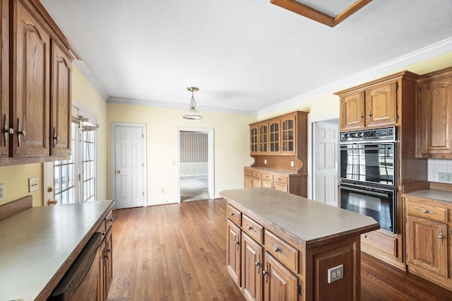 kitchen with dobule oven black, dishwasher, decorative backsplash, dark wood-style floors, and crown molding