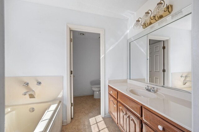 full bath featuring toilet, vanity, tile patterned flooring, baseboards, and a bath