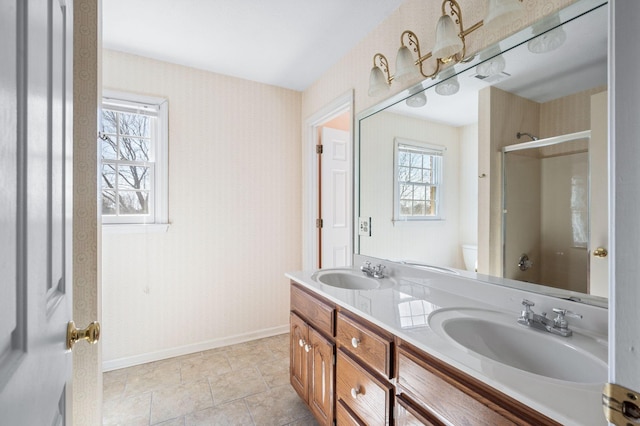 full bathroom with a shower with shower door, a sink, toilet, and double vanity