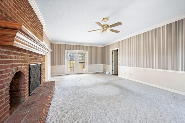 unfurnished living room featuring carpet floors, a fireplace, a ceiling fan, baseboards, and ornamental molding