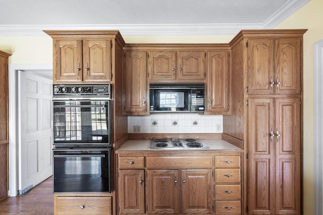 kitchen with ornamental molding, light countertops, black appliances, and tasteful backsplash