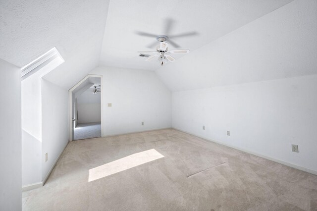 additional living space with visible vents, a ceiling fan, vaulted ceiling, and carpet flooring