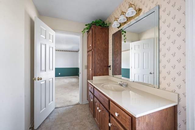 bathroom with wallpapered walls, baseboards, and vanity