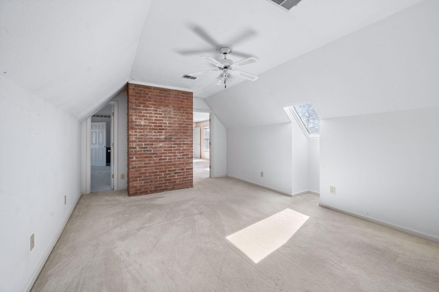 additional living space featuring vaulted ceiling with skylight, carpet floors, visible vents, a ceiling fan, and baseboards